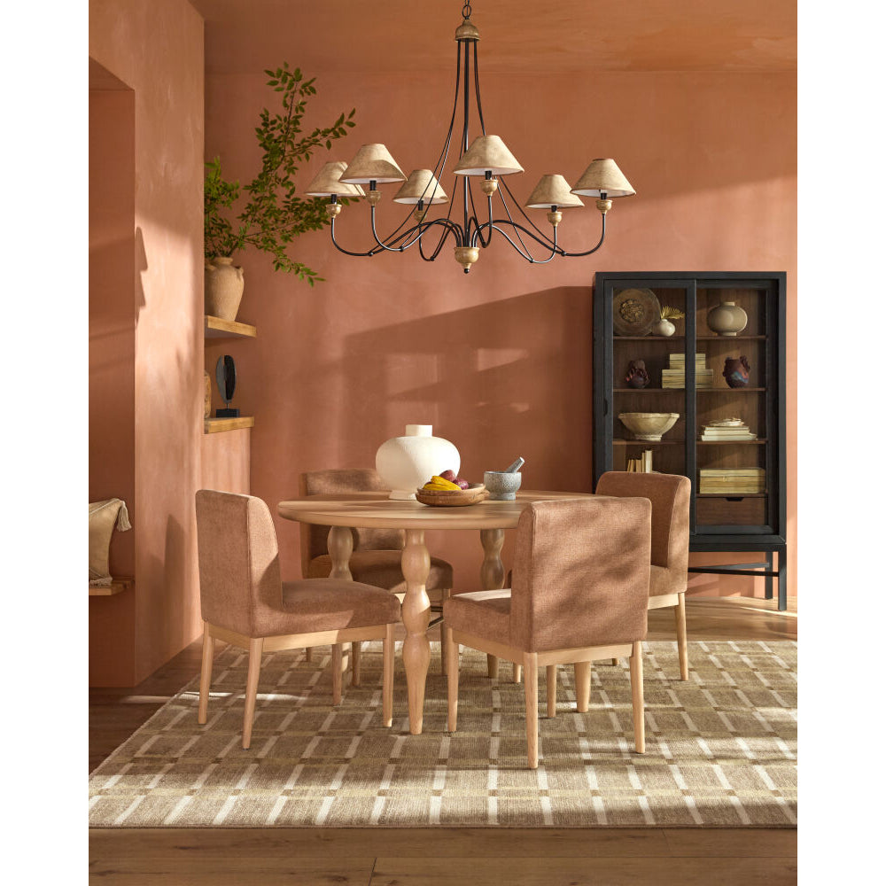 Dining room with wooden table and chairs, chandelier, and decorative items on a pink wall.