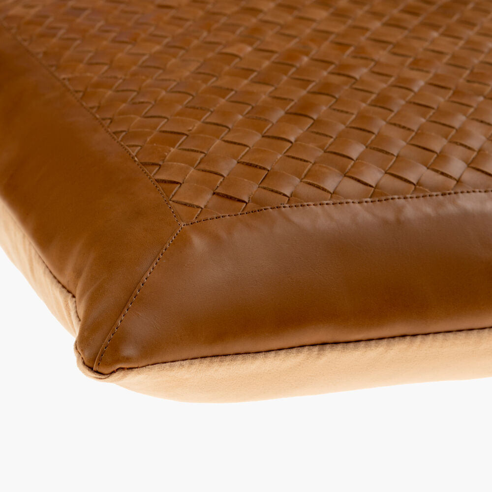 Close-up of a brown woven leather pillow on a white background