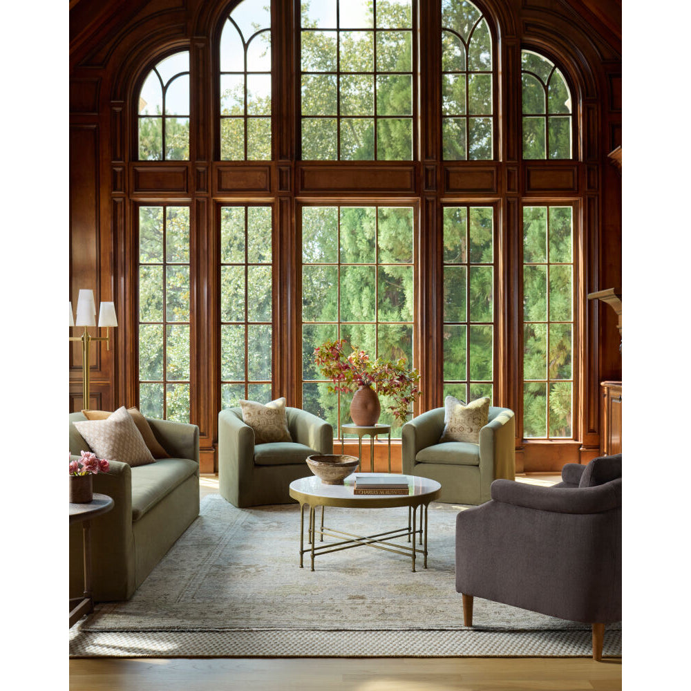 Living room with large windows, comfortable furniture, and decorative elements.