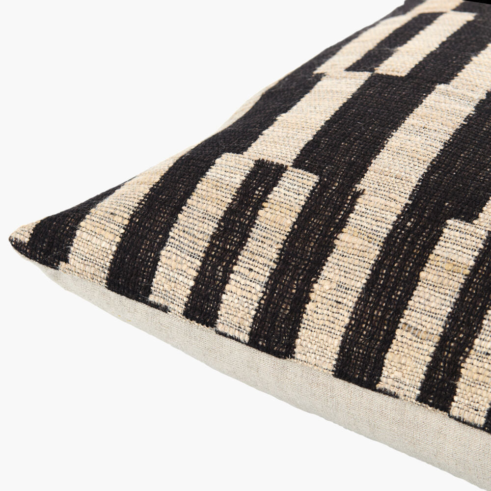 Decorative pillow with black and beige striped pattern on a white background