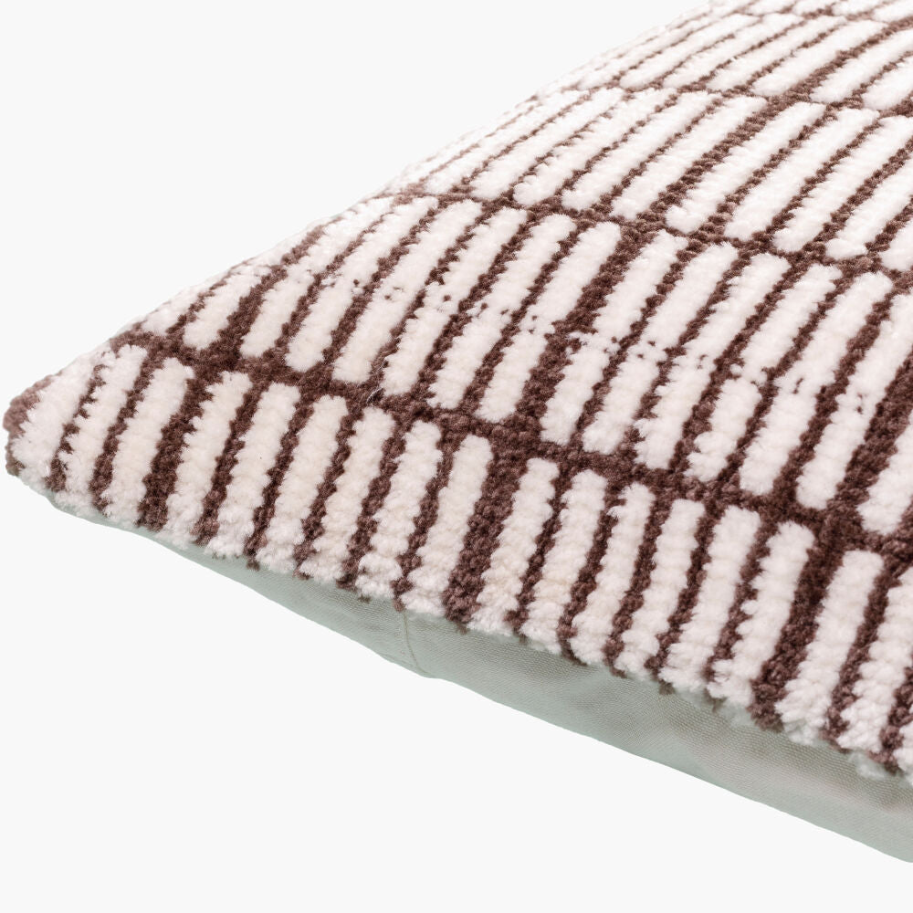 Close-up of a textured pillow with brown and white pattern on a white background
