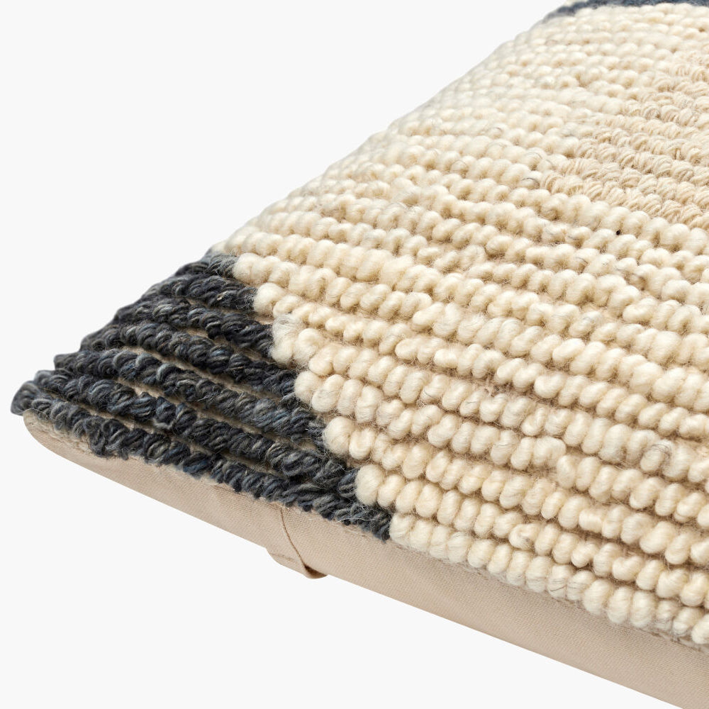 Textured pillow with black and beige pattern on a white background