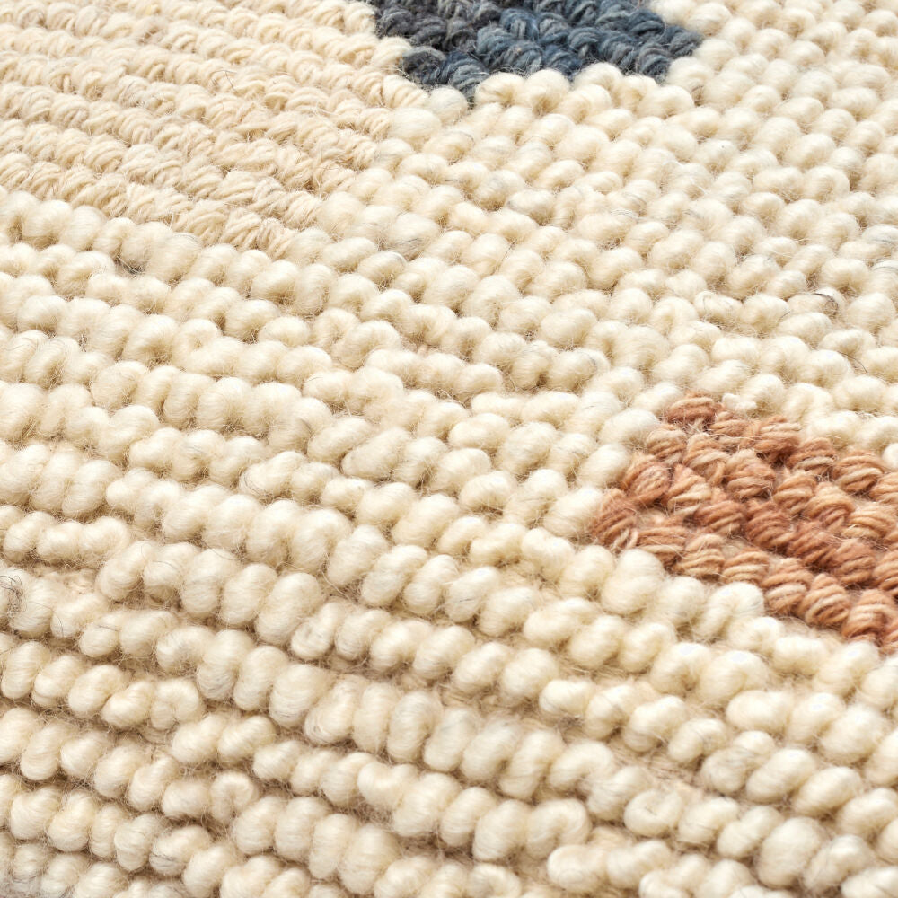 Close-up of a textured beige rug with subtle patterns