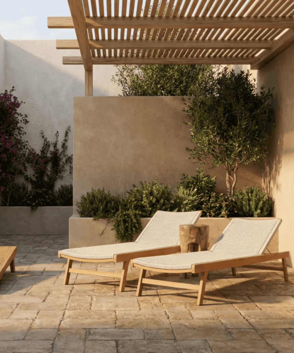 Two wooden lounge chairs with white cushions on a patio under a pergola.