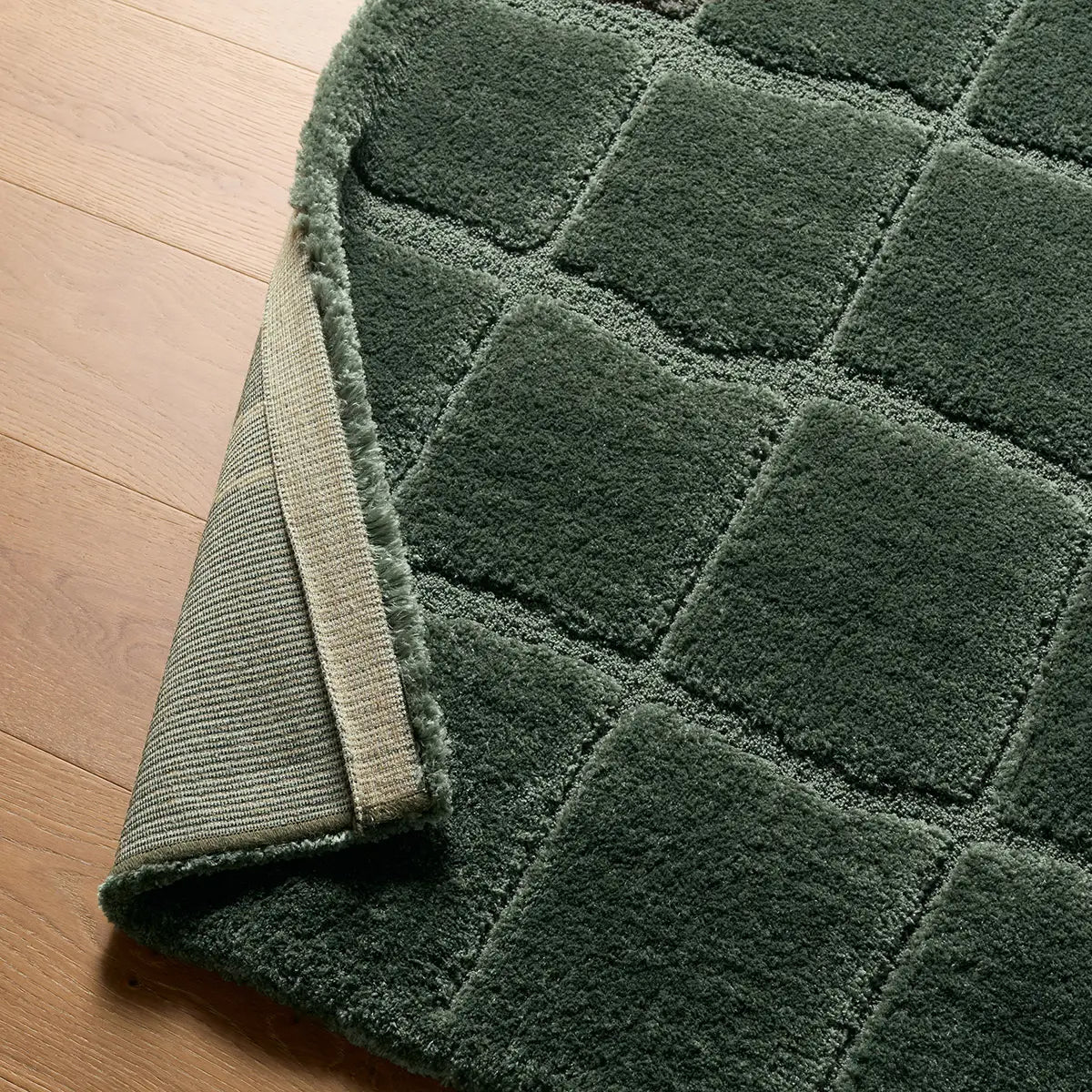 Green checkered rug on a wooden floor
