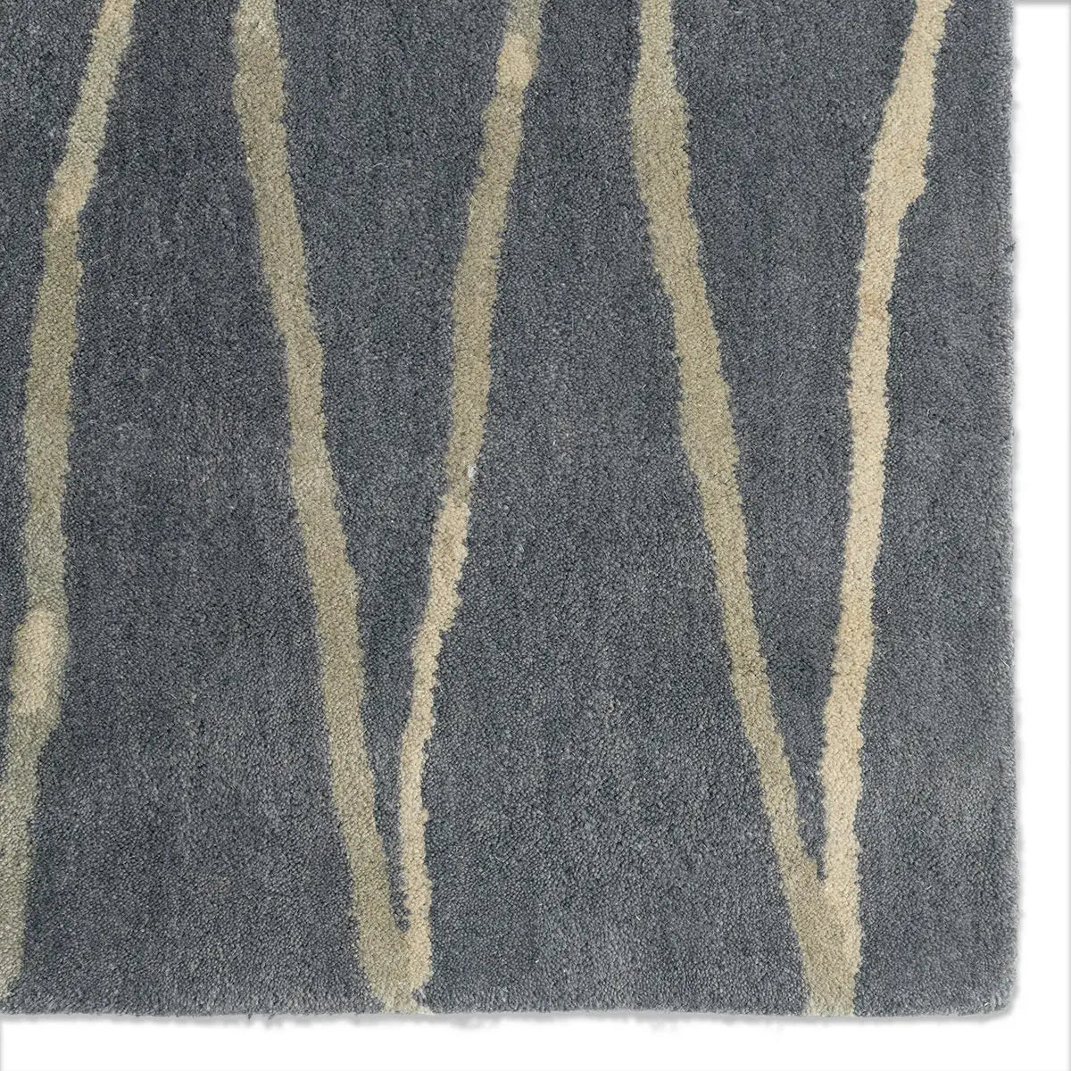 Close-up of a plush area rug with a dark gray background and vertical beige wavy stripes.