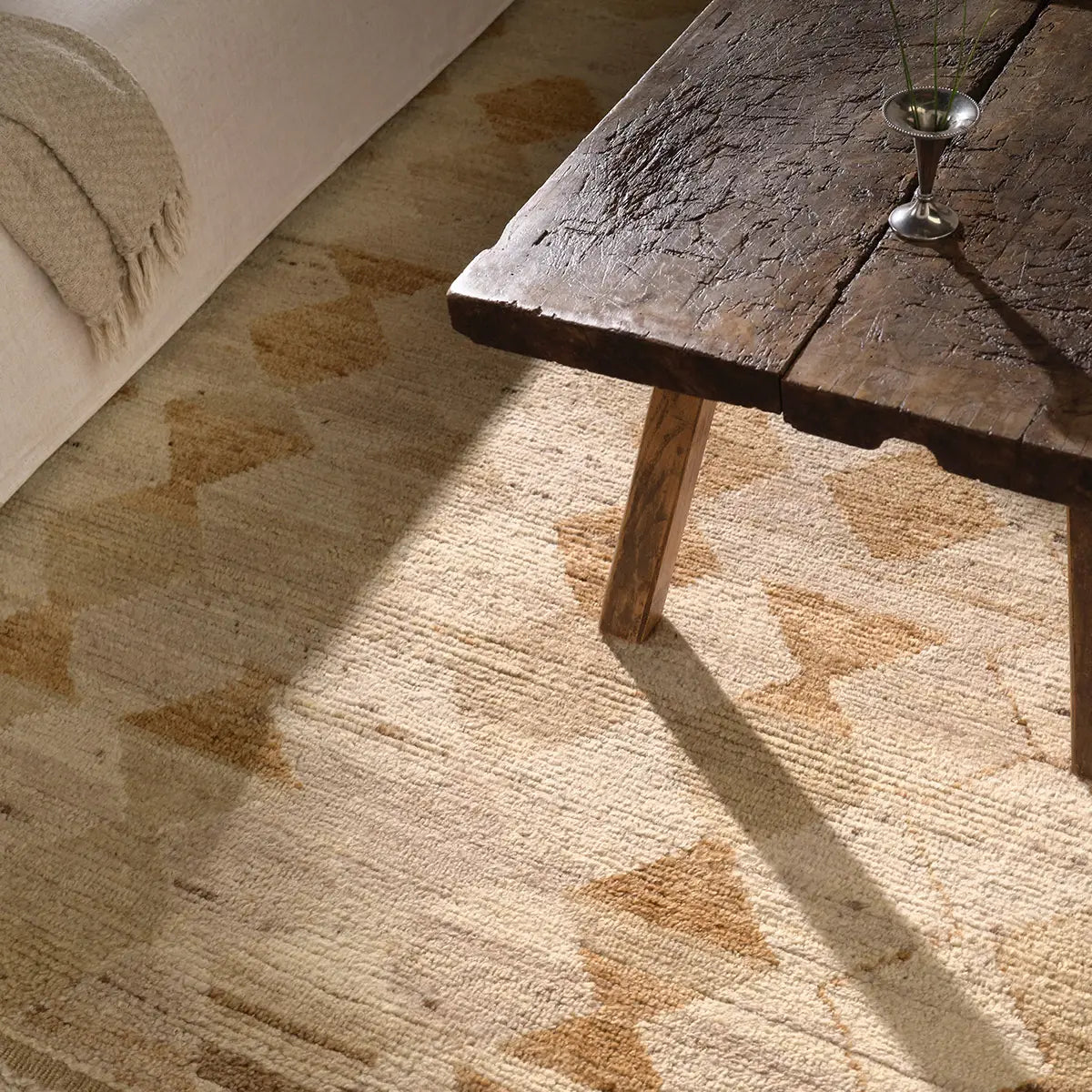 Wooden table on a textured beige rug with a neutral background