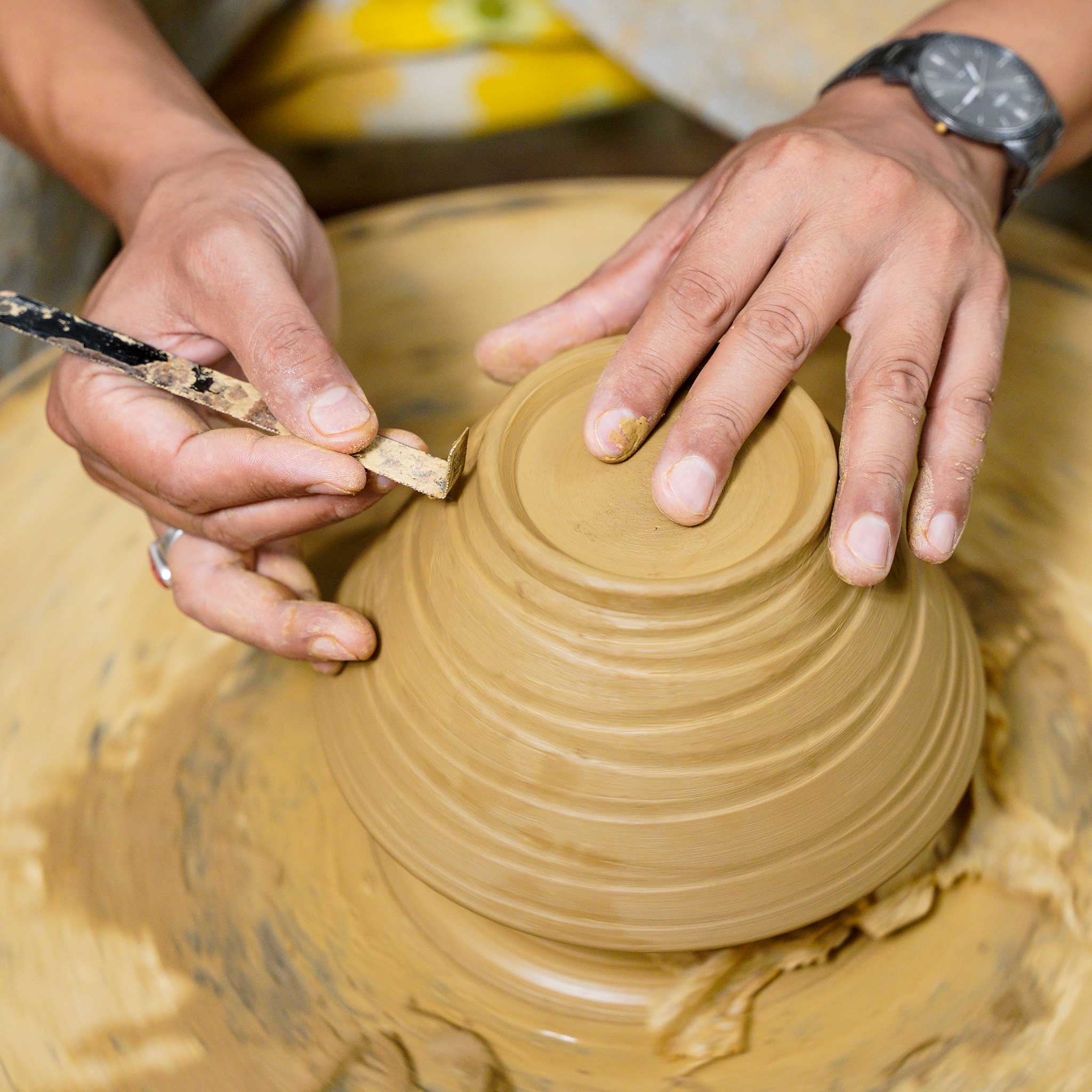 Person working with clay on a pottery wheel