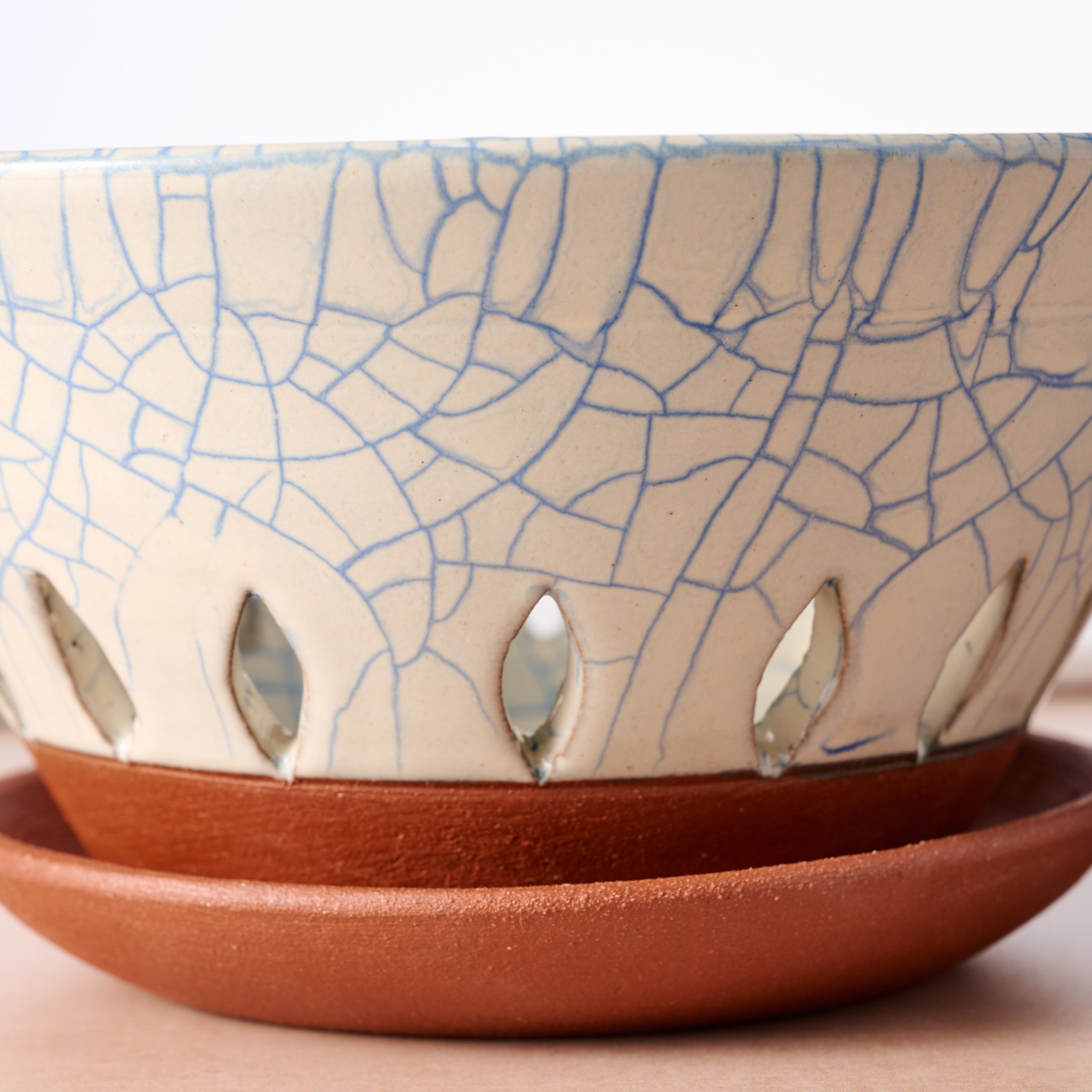 Ceramic berry bowl with cracked glaze pattern on a matching saucer