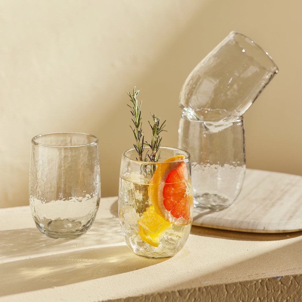 Two glasses with water and fruit on a light surface with a beige background