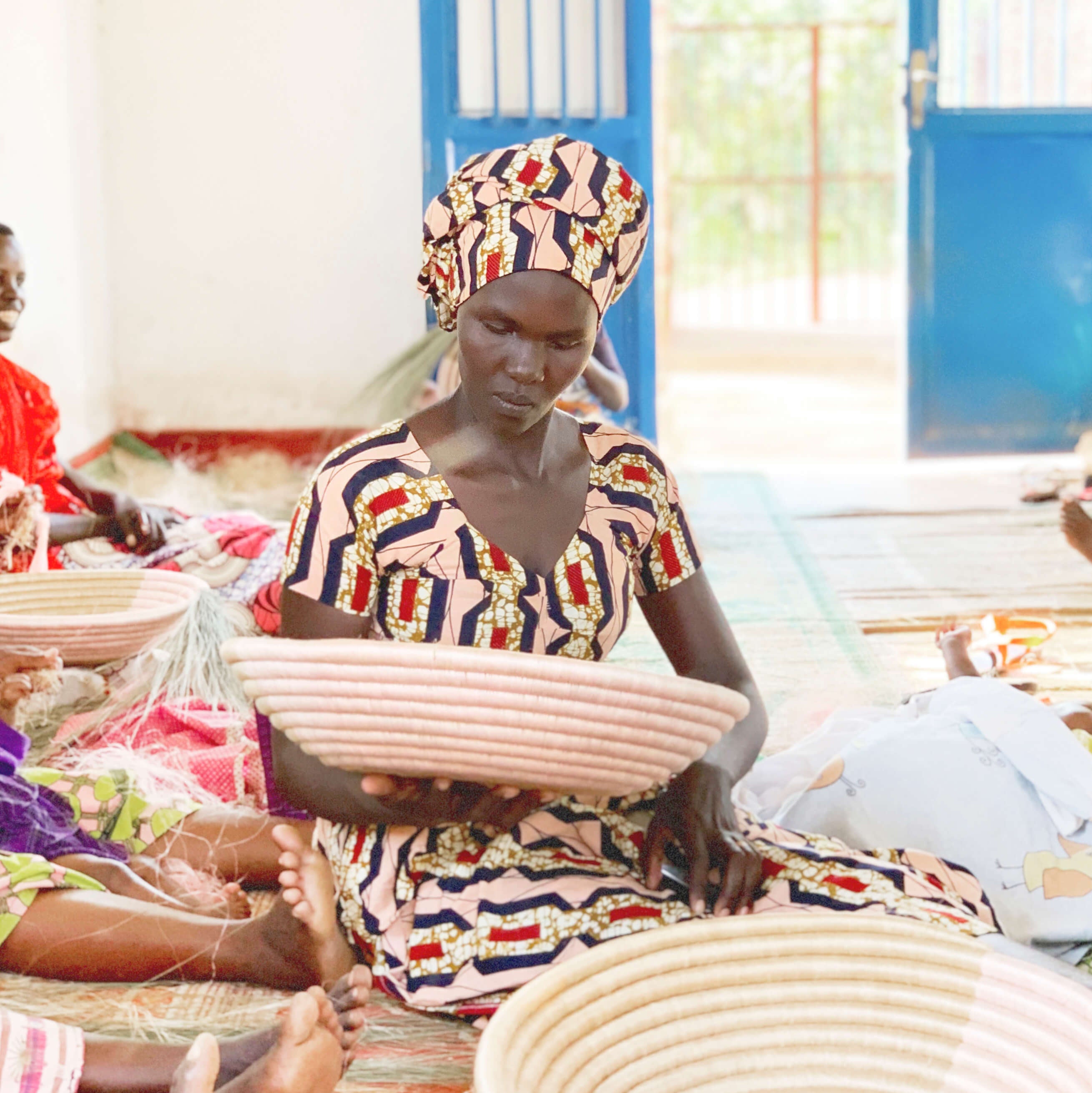Woman working with woven baskets in a workshop setting