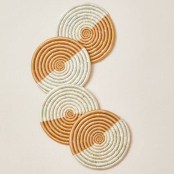 Set of four woven coasters with concentric circle pattern on a beige background