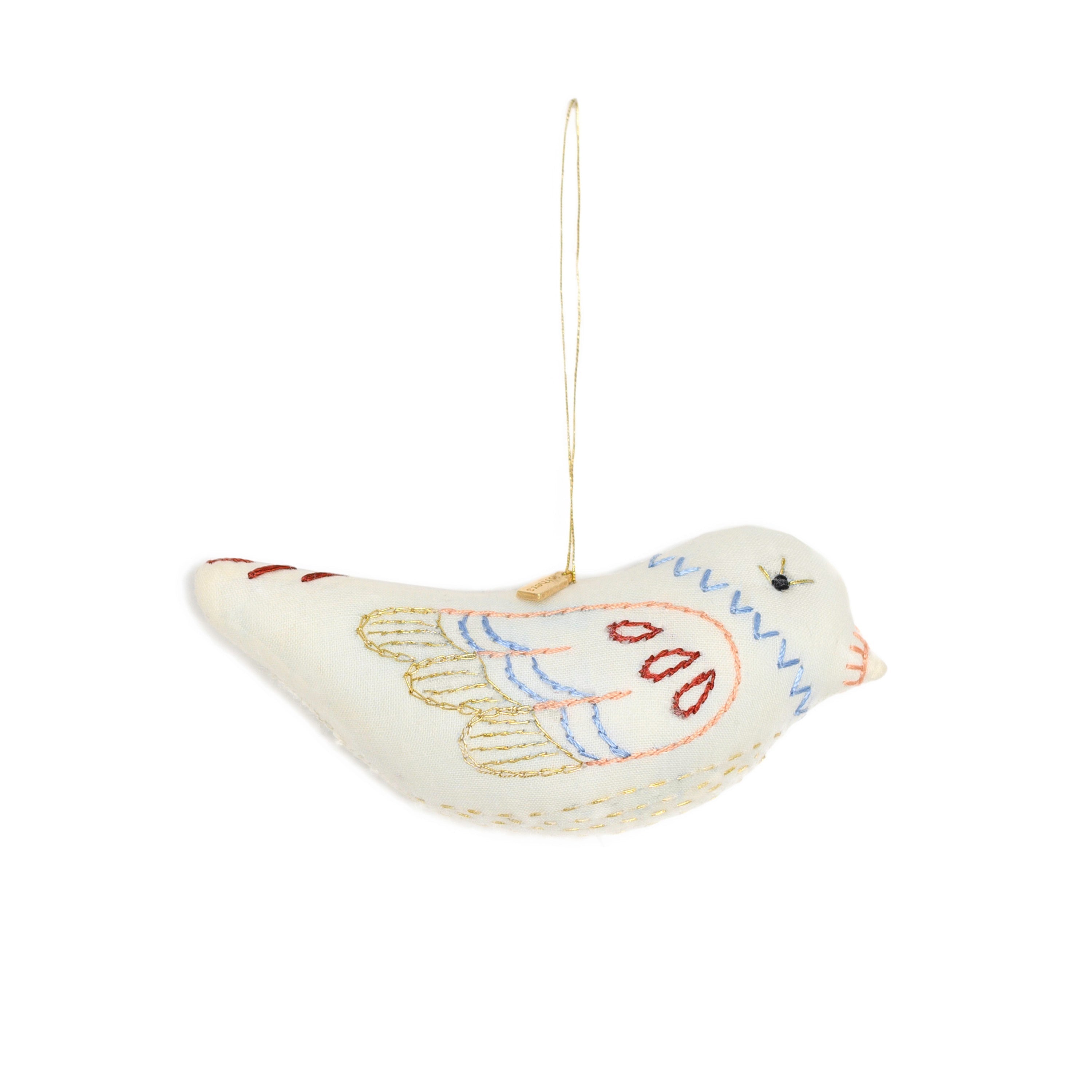 Decorative bird ornament with embroidered details on a white background