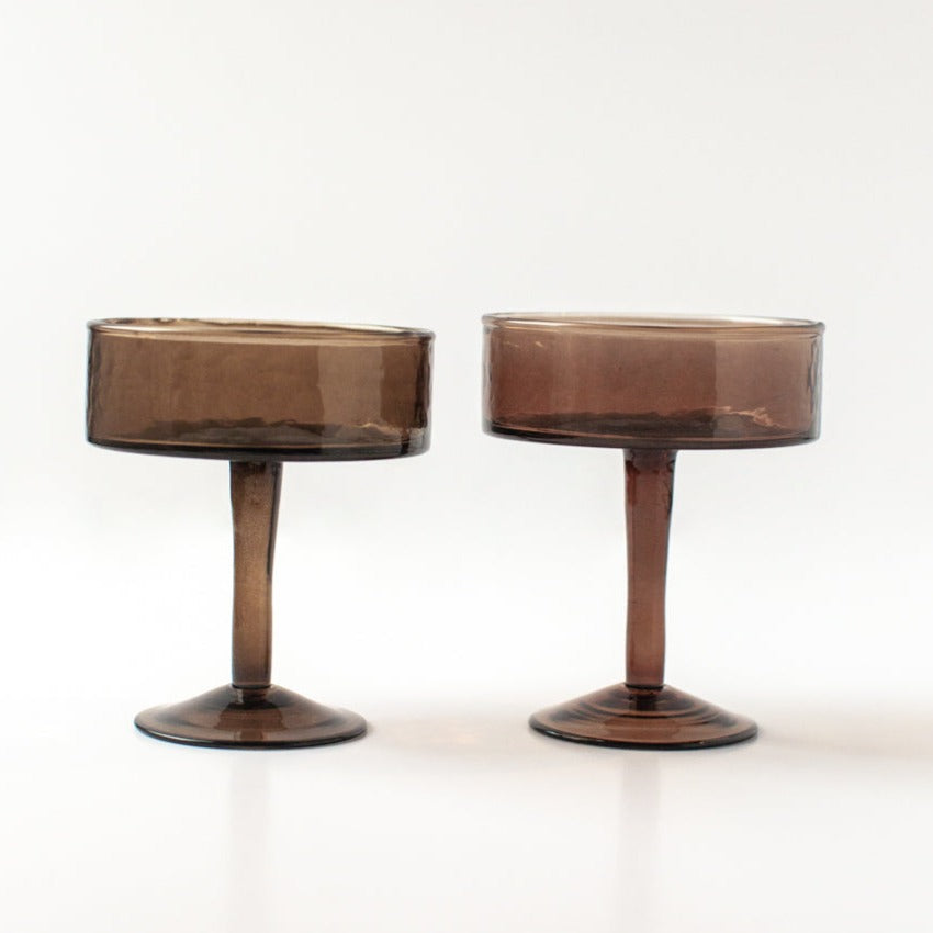 Two brown cocktail glasses on white background