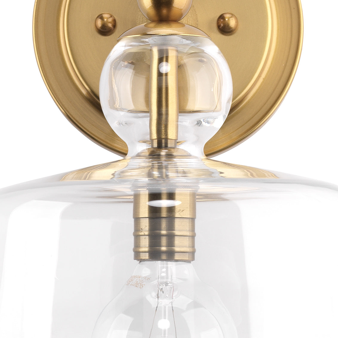 Wall-mounted light fixture with clear glass shade and gold metal accents on a white background
