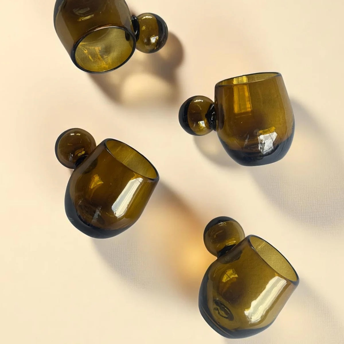 Set of amber glass tumblers on a beige background