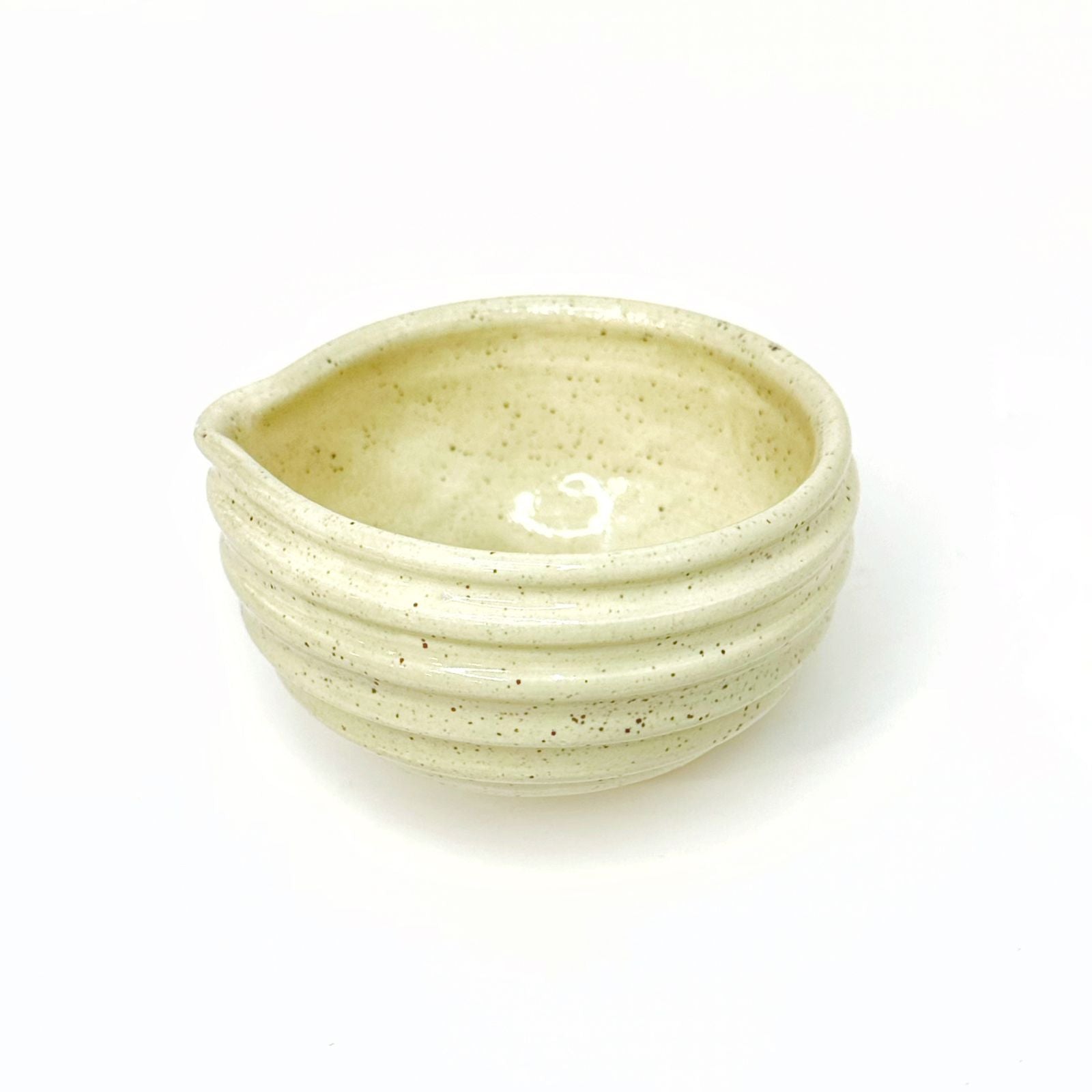 Speckled beige ceramic bowl on a white background