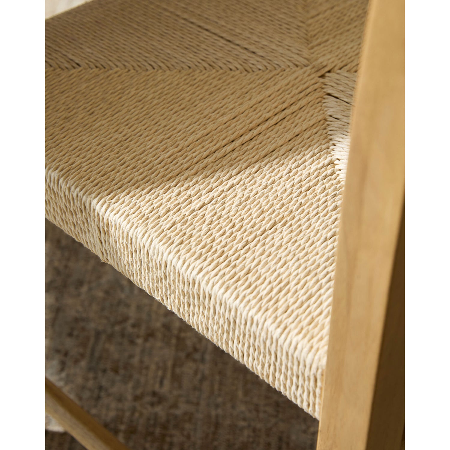 Close-up of a woven shelf with a wooden frame on a neutral background