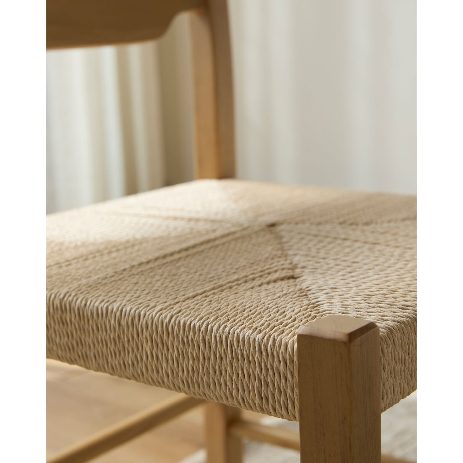 Close-up of a wooden chair with woven seat and backrest.