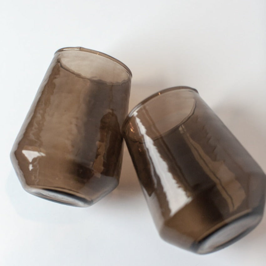 Two smoked glass tumblers on a white background
