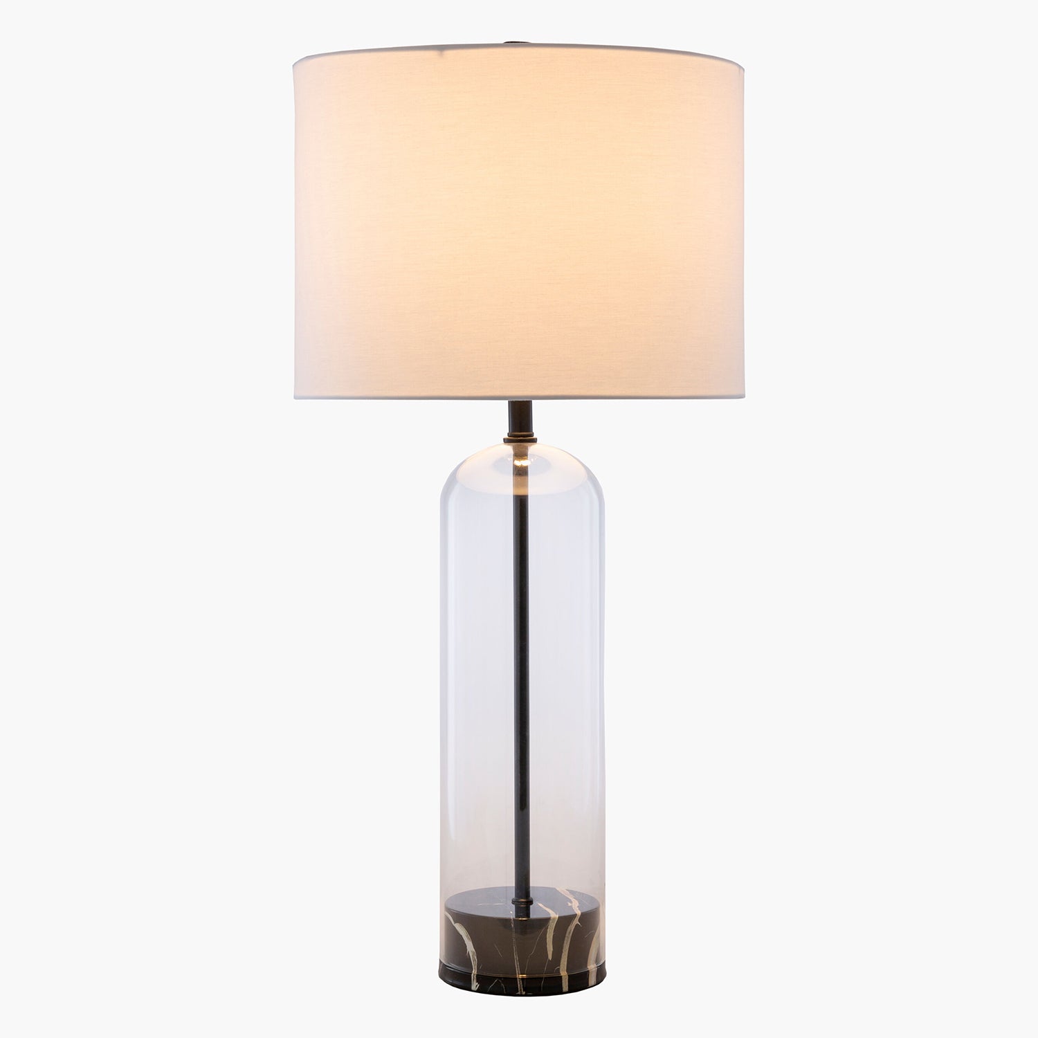 Table lamp with a clear glass base and beige fabric shade on a white background