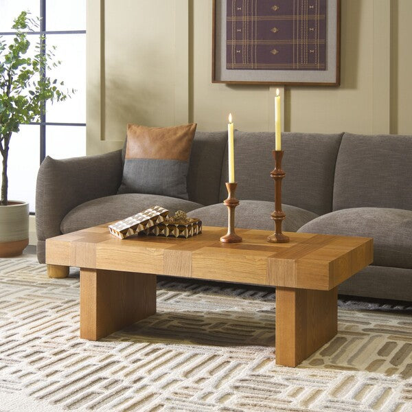 Wooden coffee table with candles and decorative items in a living room setting.