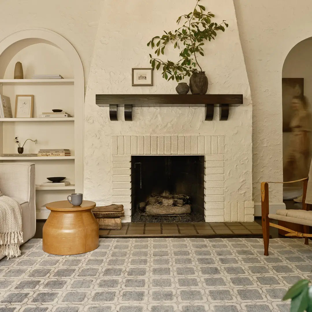 Living room with a fireplace, shelves, and decorative items.