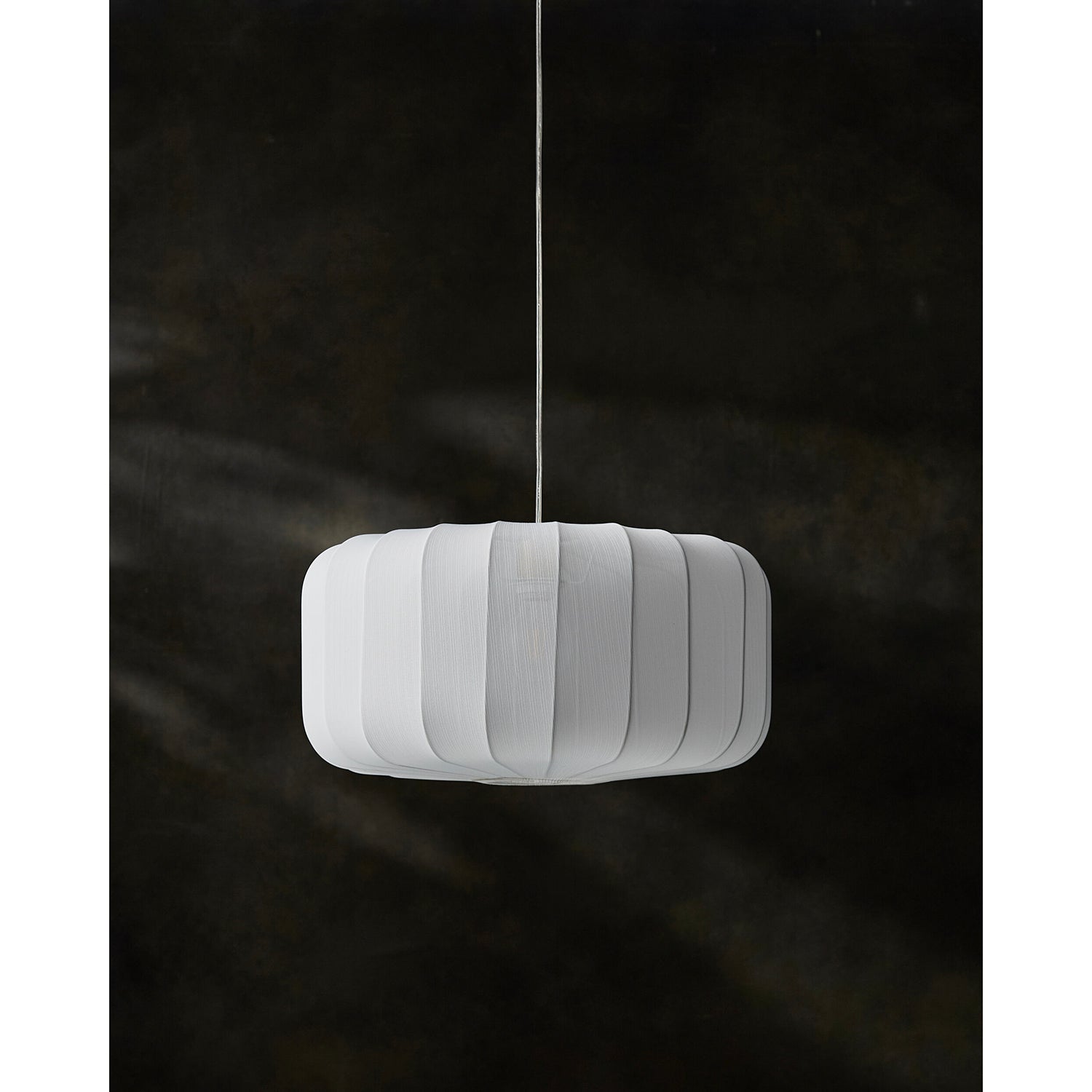 White pendant lamp hanging against a dark background