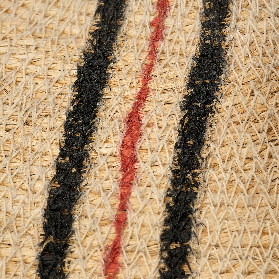 Close-up of woven straw with black and red stripes