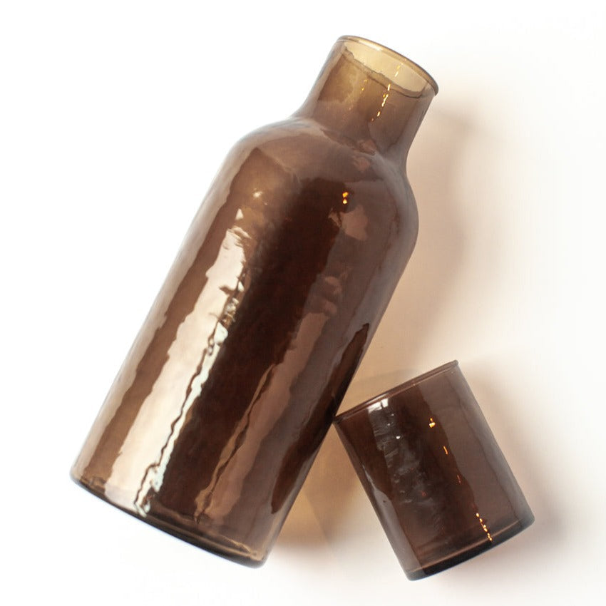 brown glass carafe set on a white background