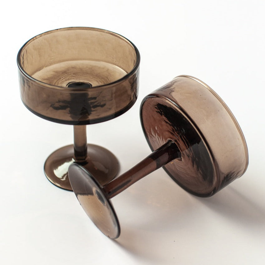 Two brown cocktail glasses on a white background
