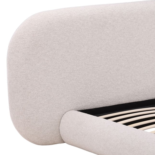 Close-up of upholstered bed with a wooden frame.