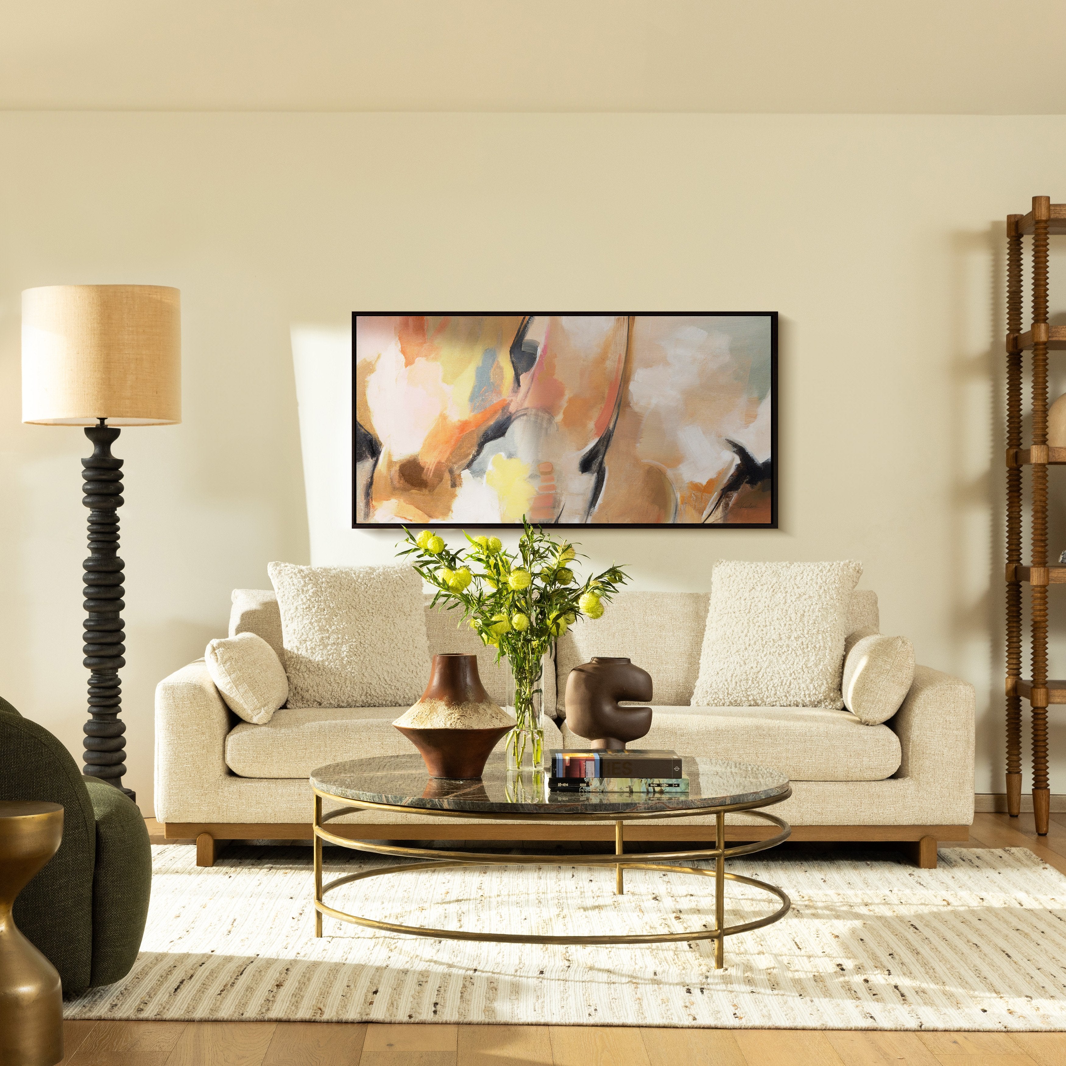 Living room with beige sofa, round coffee table, and abstract painting on wall.