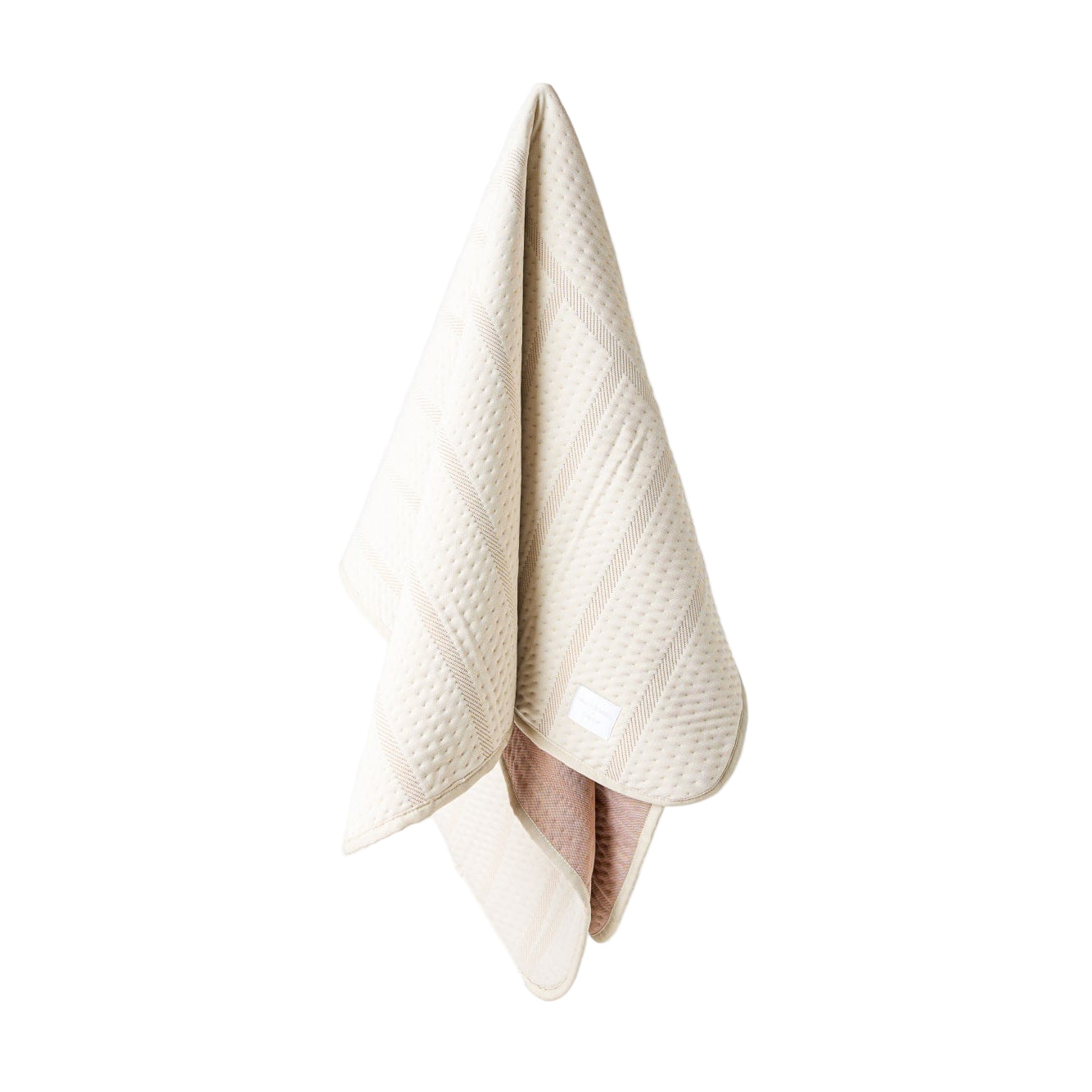 Beige textured dog blanket hanging on a white background