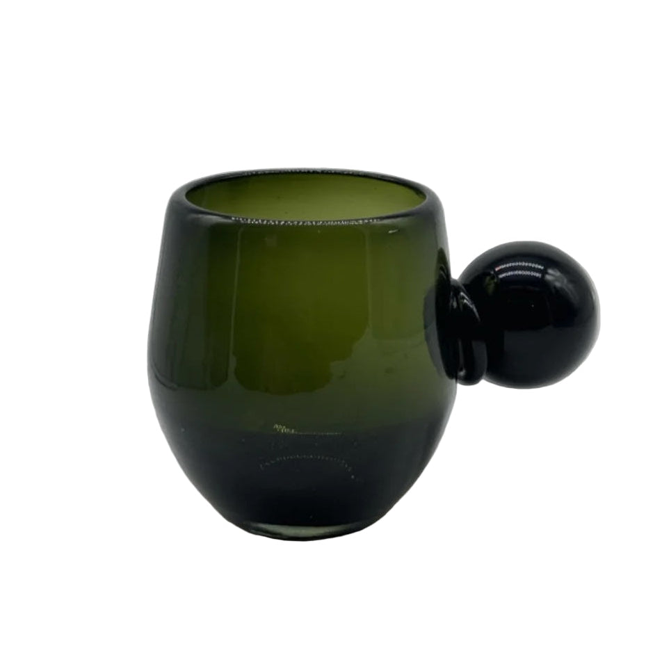 Green glass cup with a round handle on a white background