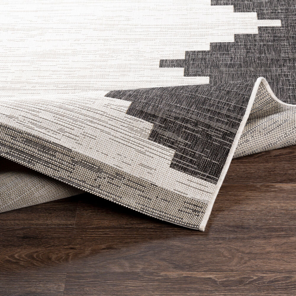 Gray and white geometric patterned rug on a wooden floor