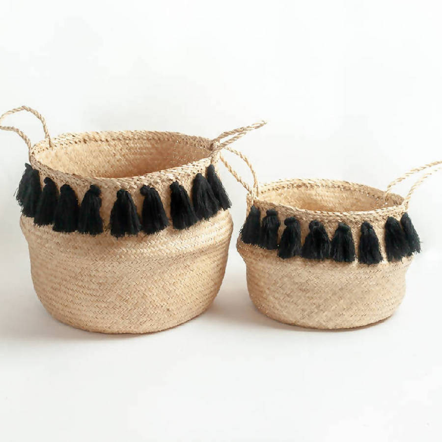 Two woven baskets with black tassels on a white background