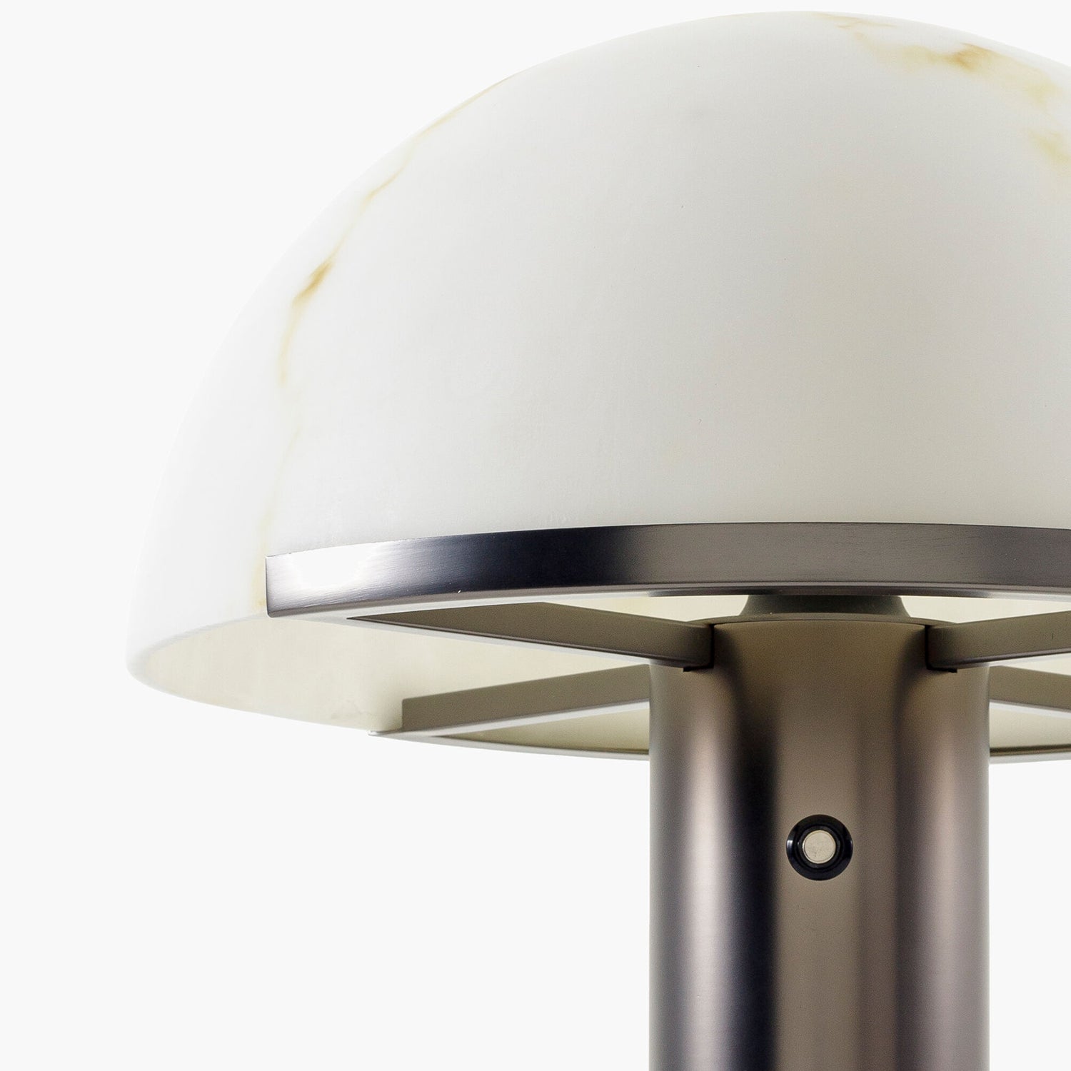 Close-up of a modern table lamp with a white shade and metallic base.