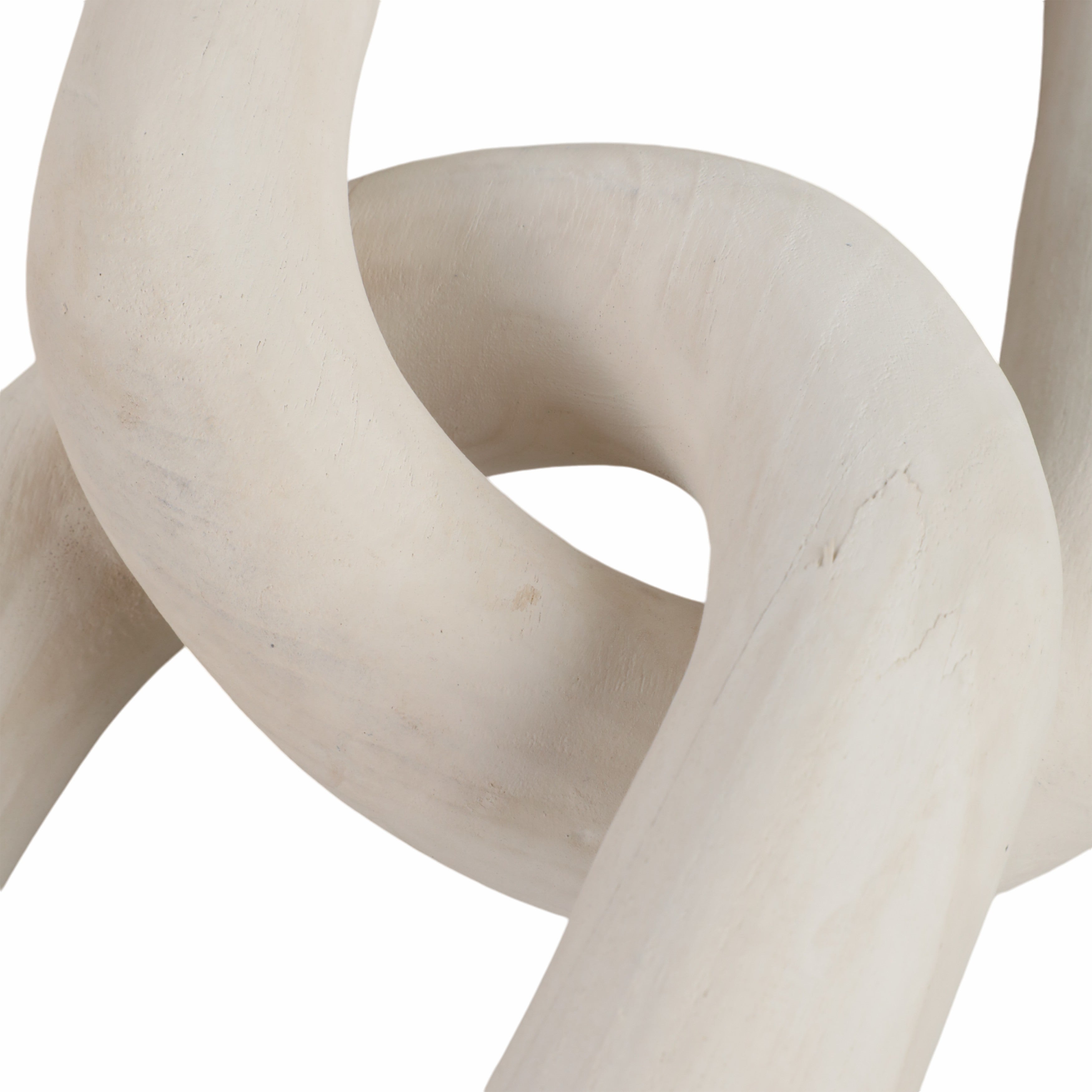 Abstract sculpture of intertwined beige stone loops on a white background