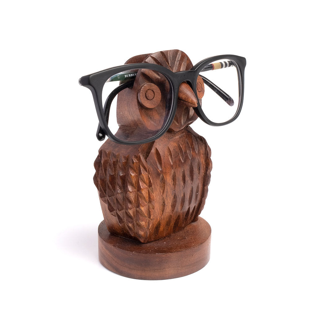 Wooden owl eyeglasses holder with black eyeglasses on a white background