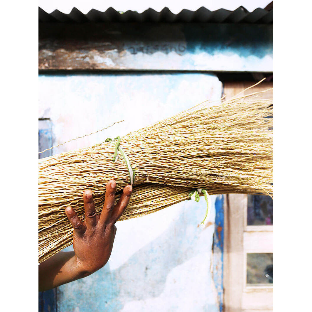 Hand holding a bundle of cotton with a blurred background