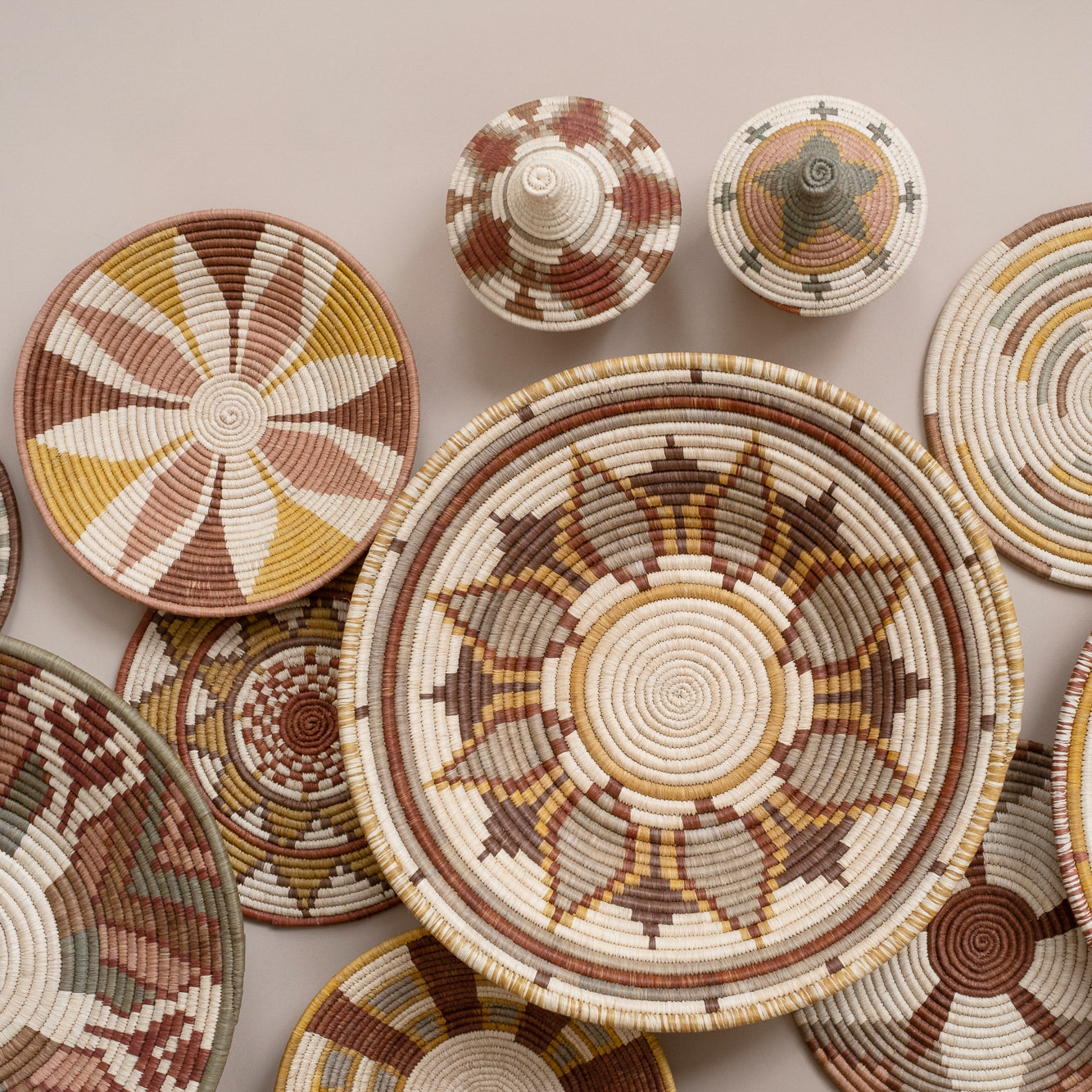 Collection of woven baskets with geometric patterns on a neutral background
