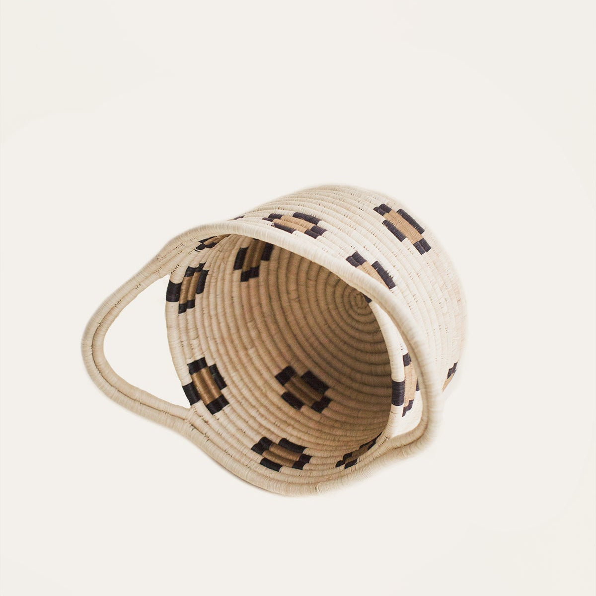 Woven basket with decorative patterns on a light beige background