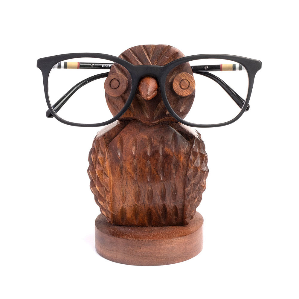 Wooden owl-shaped glasses holder with eyeglasses on a white background
