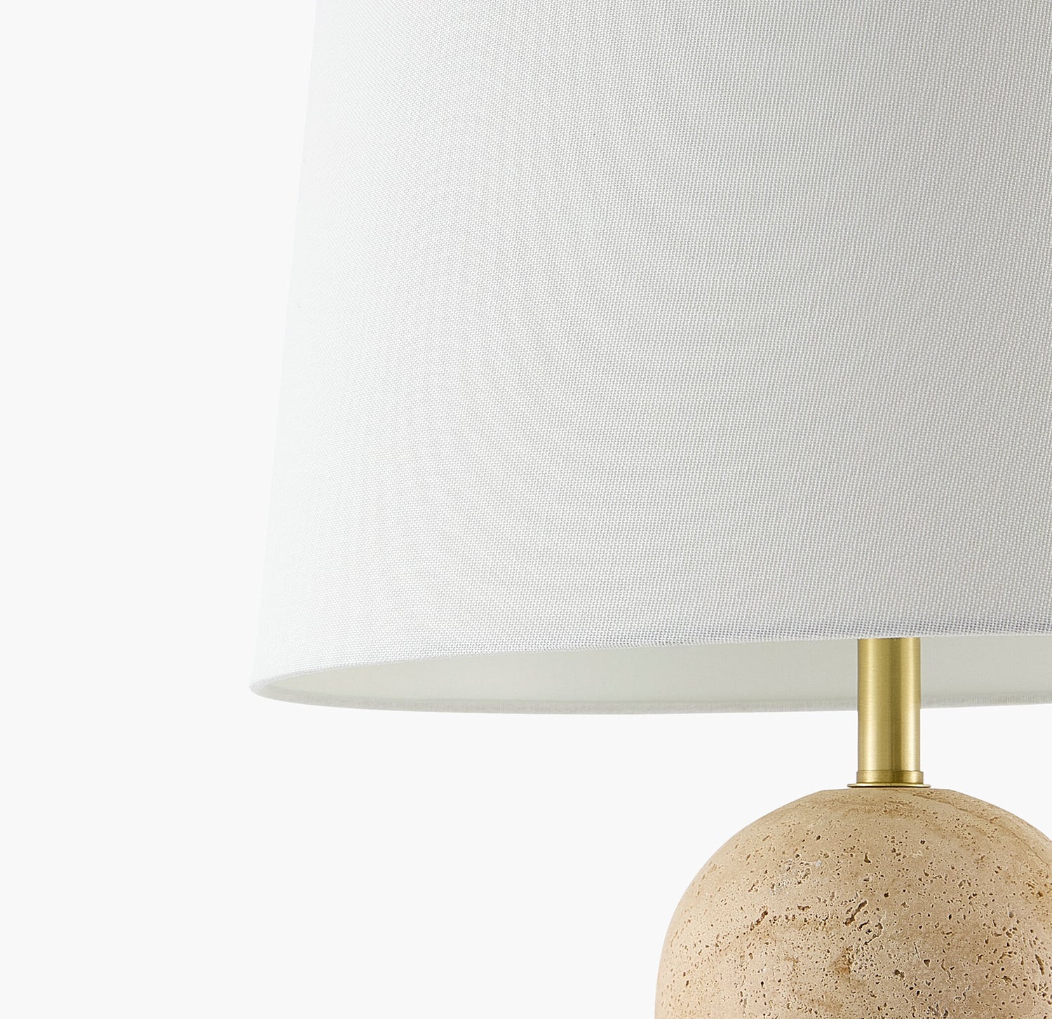 Table lamp with a beige stone base and white shade on a white background