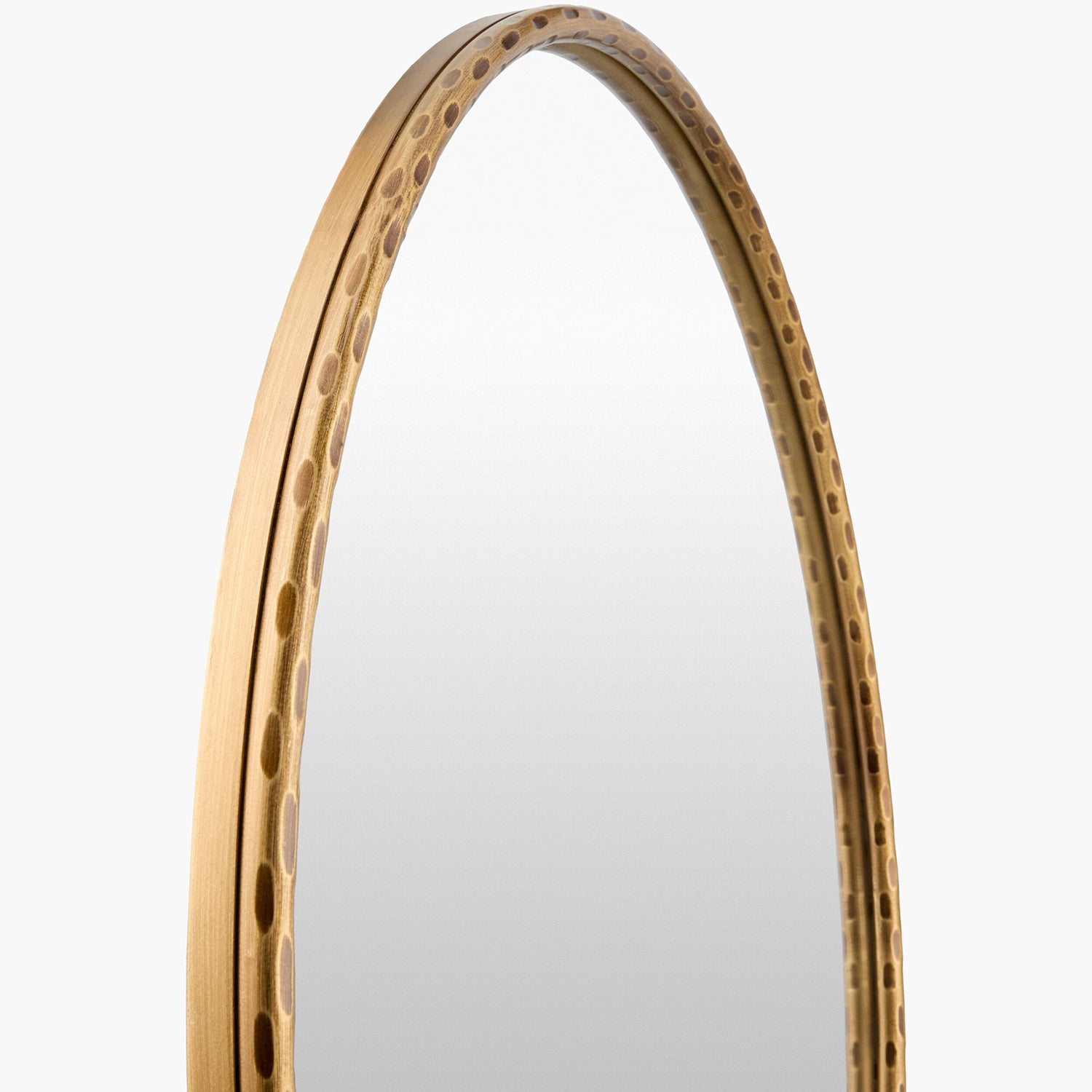 Round mirror with a textured gold frame on a light gray background