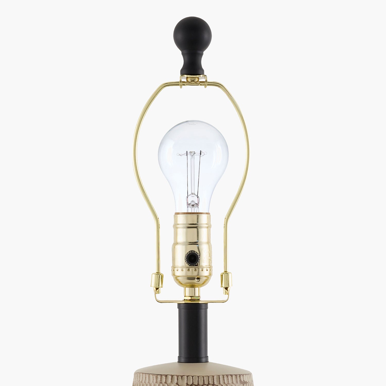 Vintage-style lamp with clear bulb and gold fixture on a white background