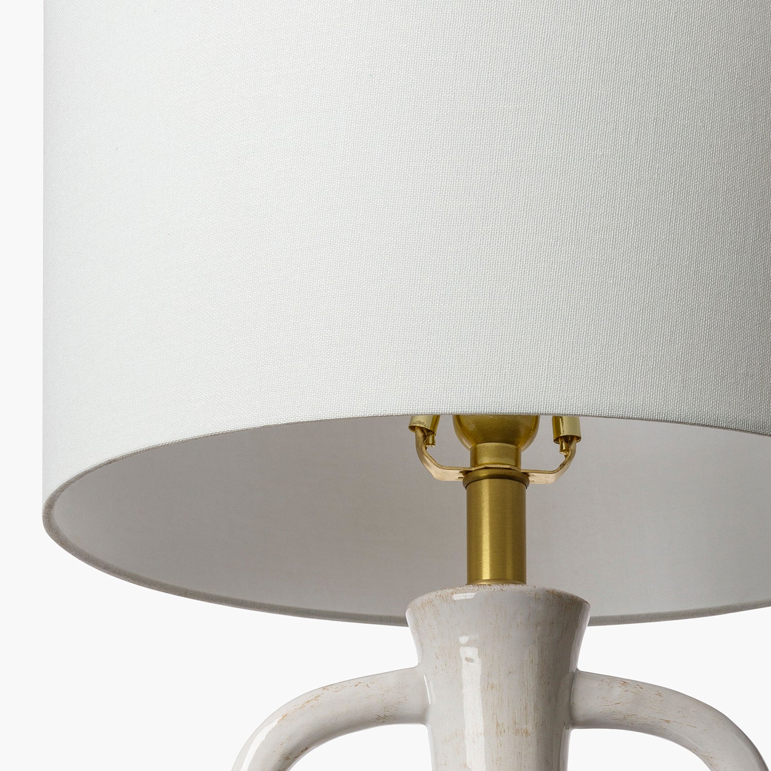 Lamp with white shade and gold fixture on a white background