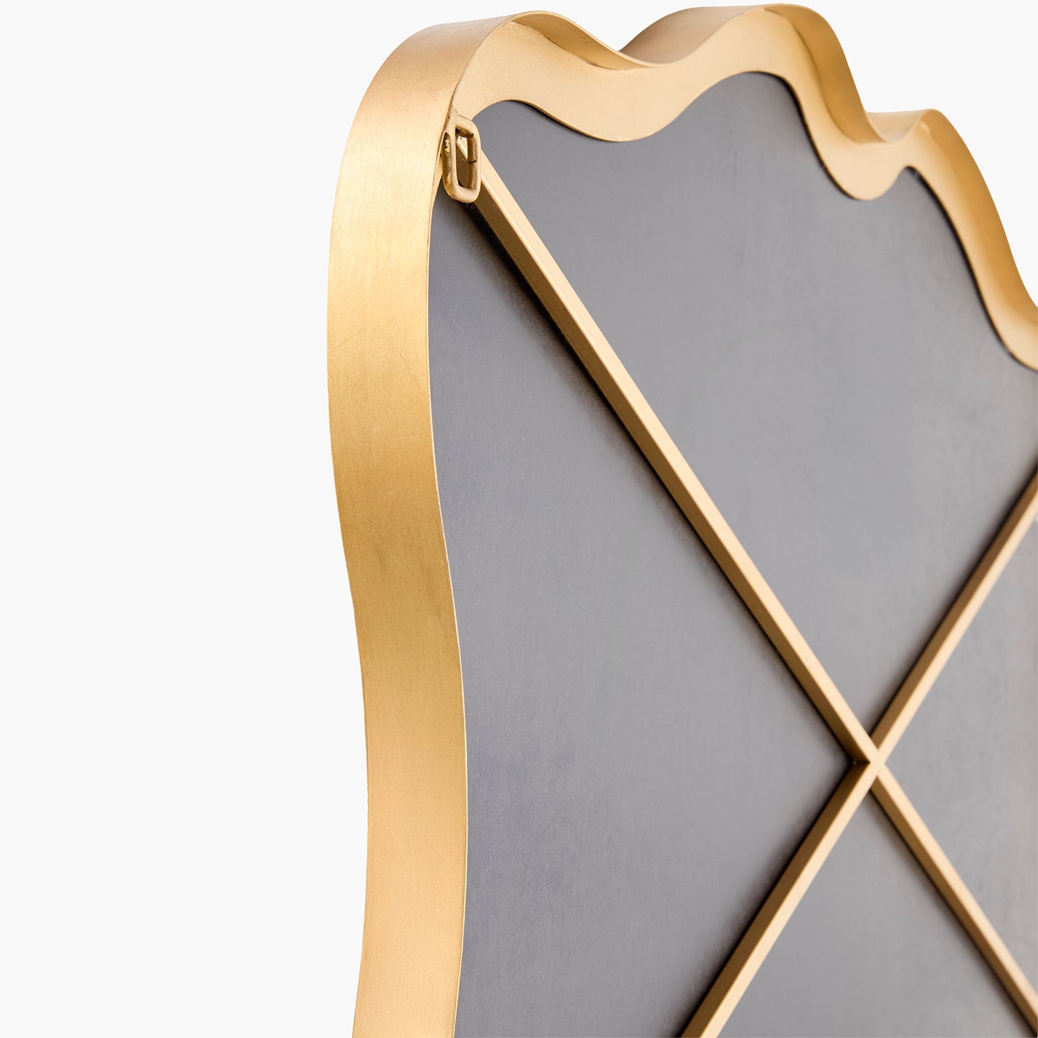 Decorative wall mirror with gold frame and black backing on a white background