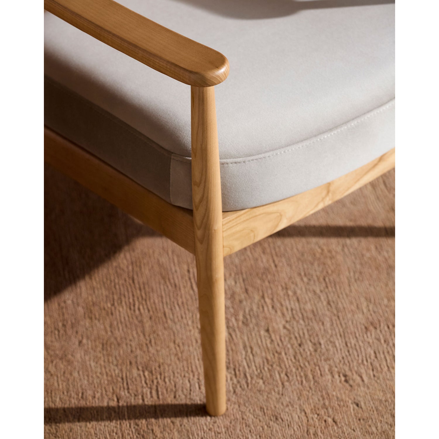 Wooden chair with a white cushion on a brown carpet